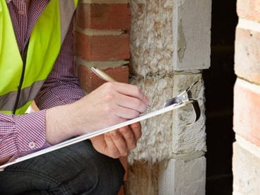 construction man taking notes about a building