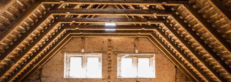 Bare attic with no insulation and 2 windows.